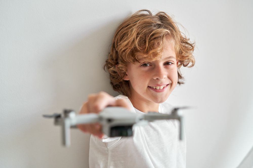 Cheerful boy holding toy drone