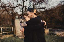 Happy couple hugging near tree in park