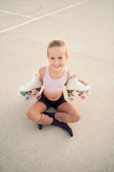 Positive roller skater girl holding white quads