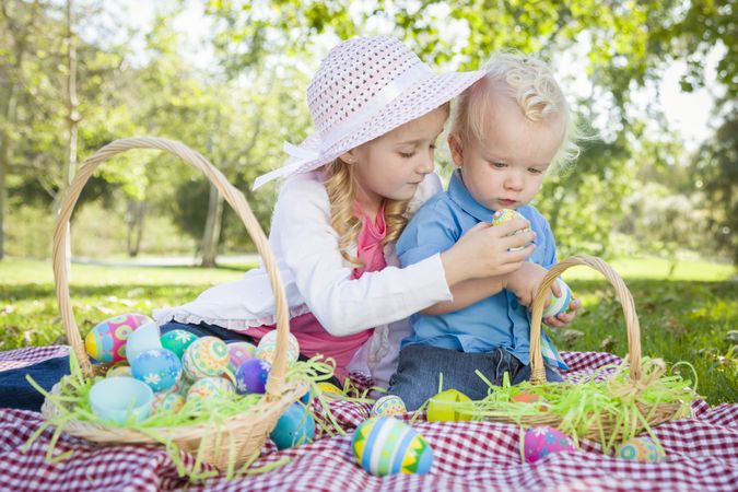 Cute Young Brother and Sister Enjoying Their Easter Eggs Outside