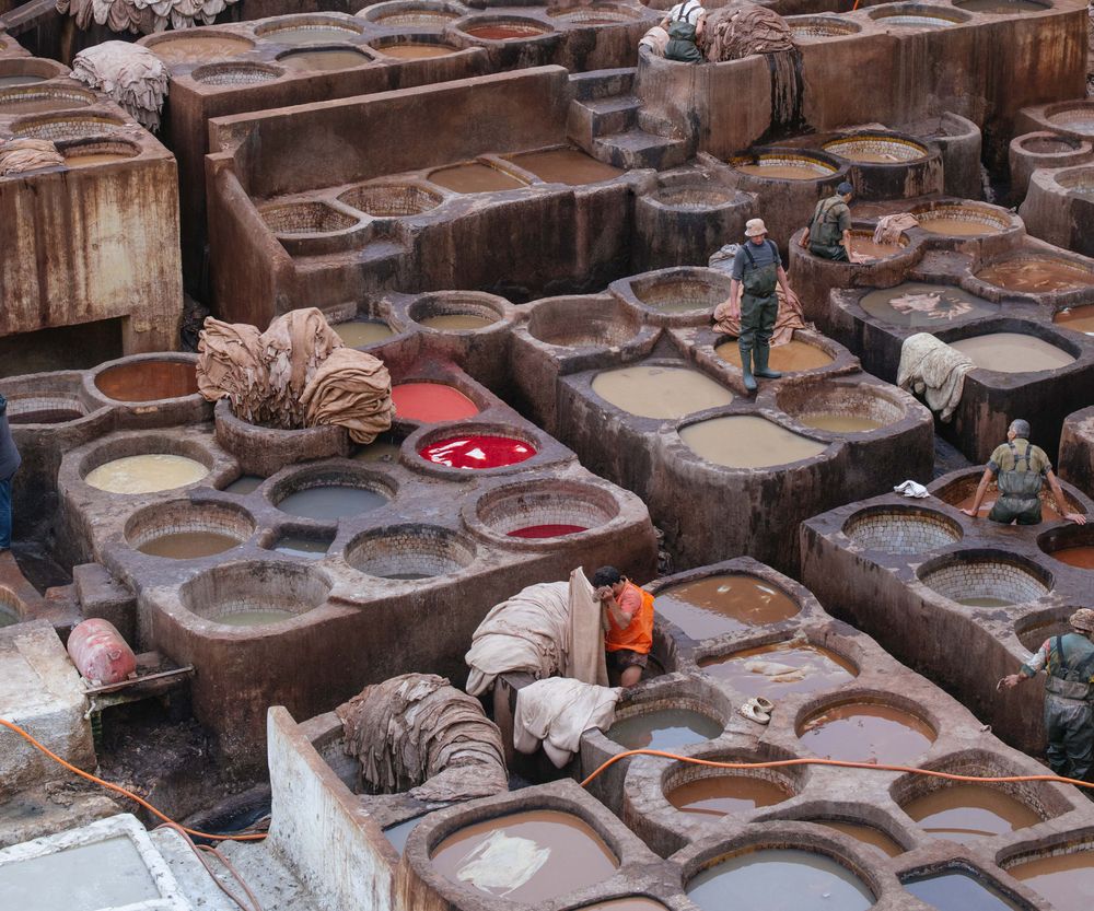 Men dyeing sheep skin in large leather tanning and dyeing vats in Fez, Morocco