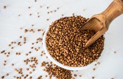 Top view of organic raw buckwheat seeds in a bowl on table 