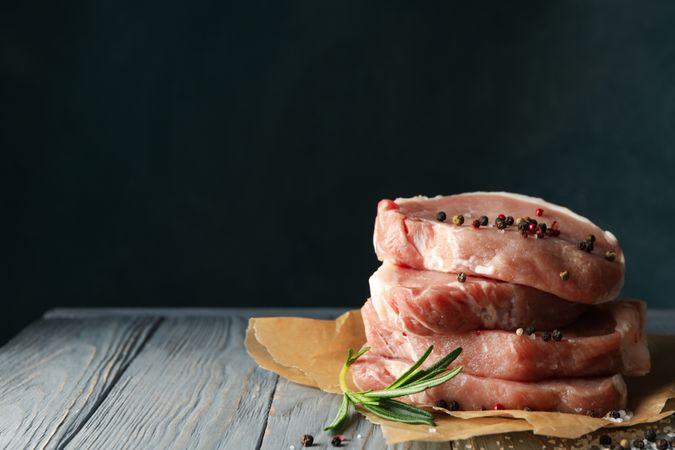 Composition with raw meat for steak and spices on wooden background