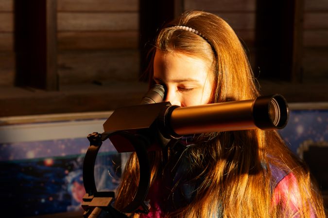 Young girl observes through solar telescope