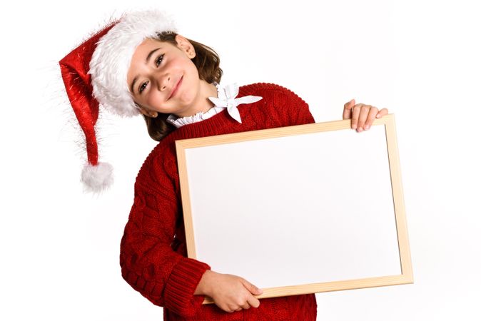 Girl in Santa costume holding blank board
