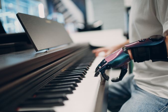 Close-up shot of man playing the piano with prosthetic hand