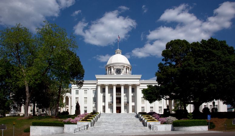Front view of Alabama State Capitol building on sunny blue sky day