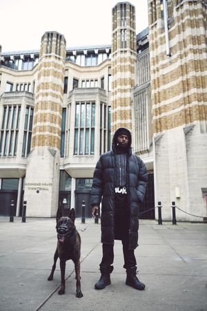 London, England, United Kingdom - June 6th, 2020: Man in puffer jacket with muzzled dog