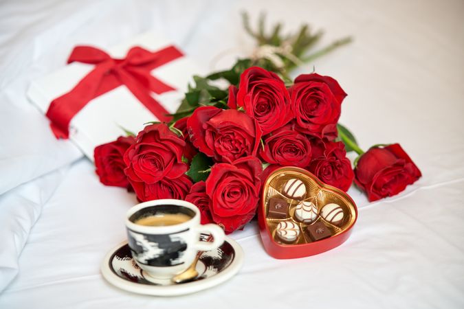 Bouquet of red roses and cup of coffee chocolates
