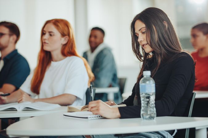 Focused woman taking notes down during lecture