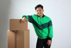 Online Driver Pose on Stacked Cardboard, Gojek Grab Delivery Concept Online Shopping
