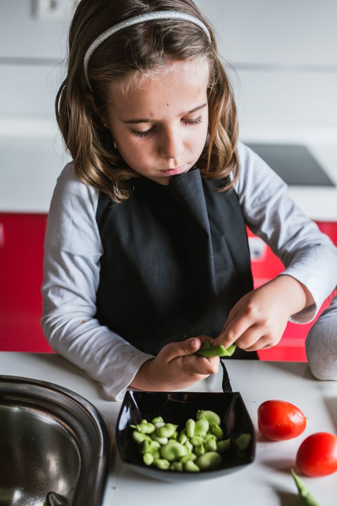 Young girl preparing vegetables for salad