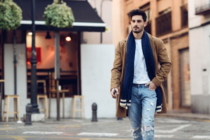 Man strolling in winter jacket and scarf in the street