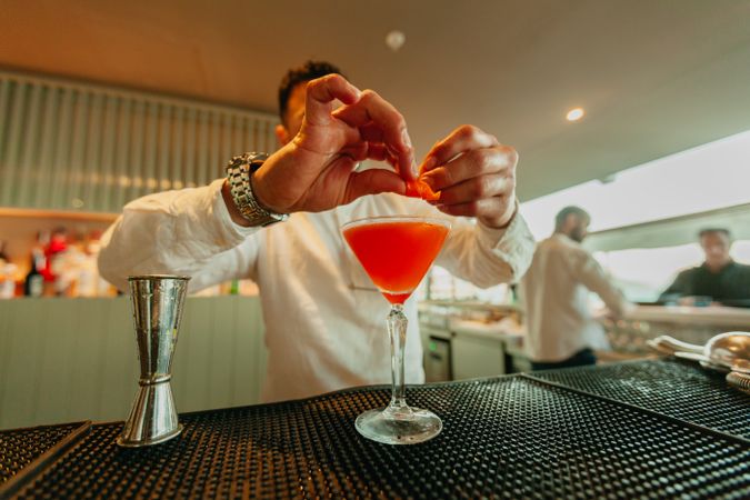 Cheerful man preparing a cocktail in a bar.
