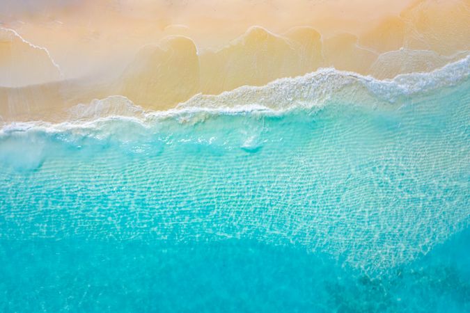 Aerial shot of blue tropical water coming up on the beach
