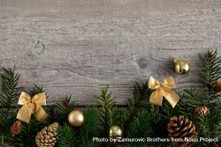 Pine branches bordering bottom of wooden background with gold ribbons 0LPNe0