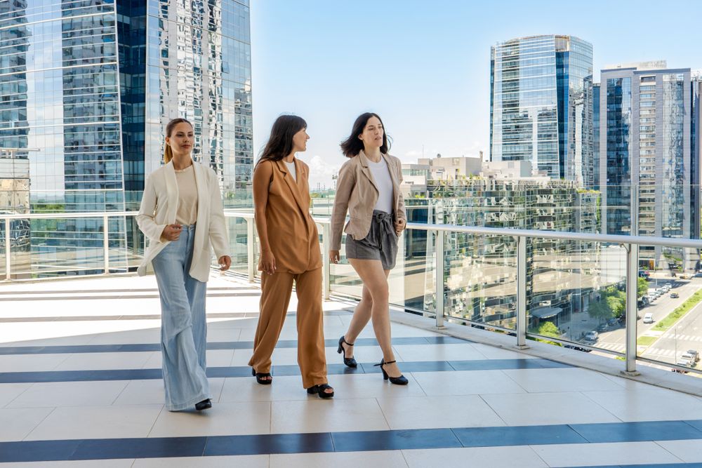 Three businesswomen walking on a tower building terrace
