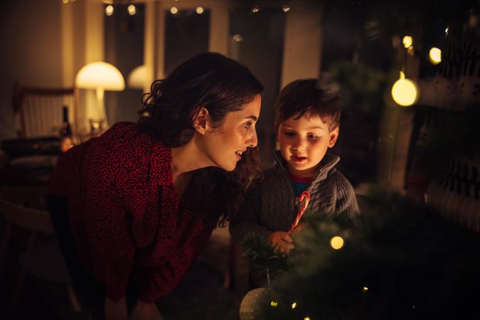 Mother and son with candy cane inside their house at Christmas