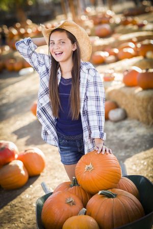 Girl Playing with a Wheelbarrow at the Pumpkin Patch.