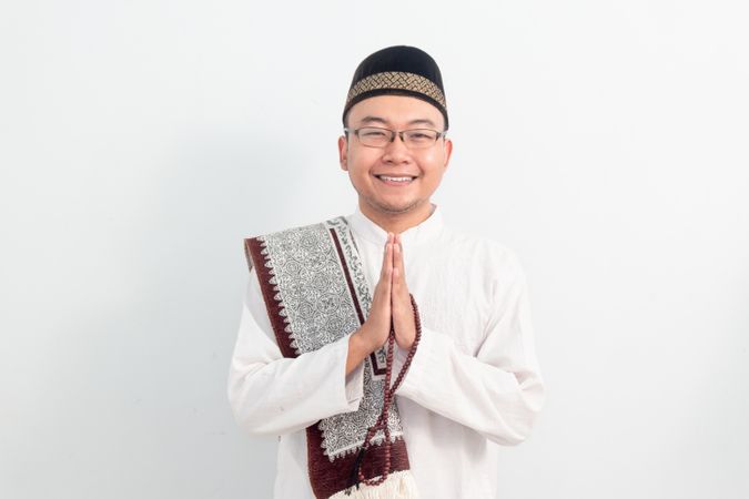 Asian Muslim man smiling doing greeting pose during Ramadan