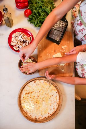 Top view of hands making pizza in the kitchen