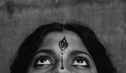 Grayscale photo of woman's forehead with Tilaka 4jwGrb