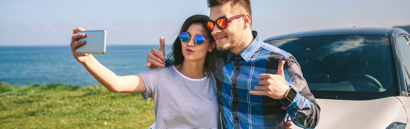 Young couple doing a selfie on the car