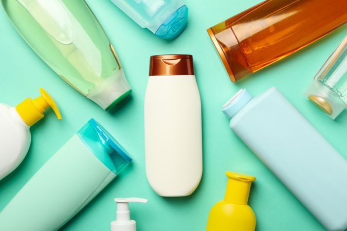 Blank bottles of cosmetics on mint background