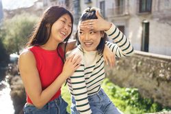 Female friends sitting outside on sunny day