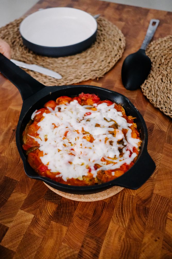 Melted cheese atop meal in cast iron