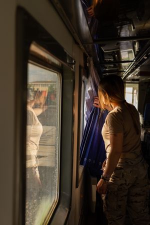 Military woman travelling looking out van window