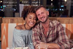Cheerful multiethnic couple in restaurant