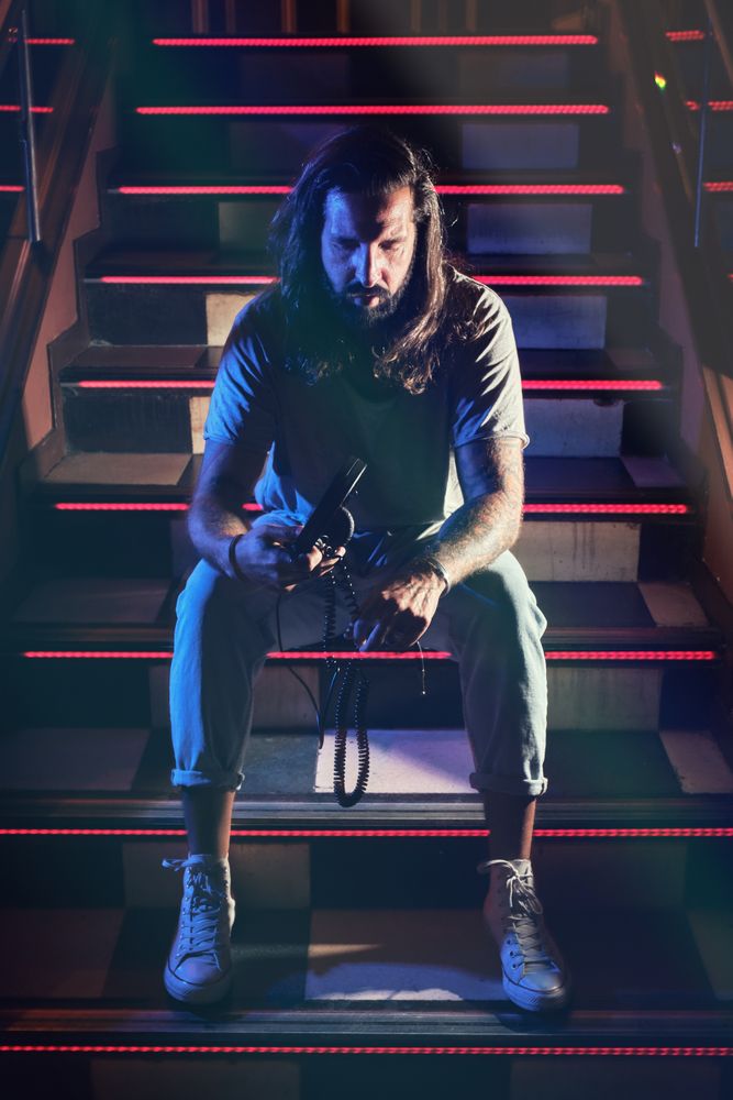 Man with headphones on steps in club