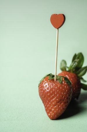 Ripe strawberry with a heart-shaped toothpick