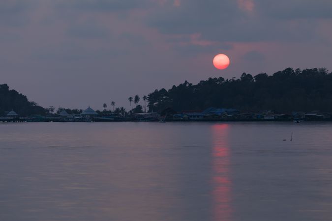 A red sun sets behind the rainforest on the island of Koh Chang, Gulf of Thailand