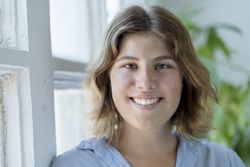 Portrait of happy young woman smiling by window