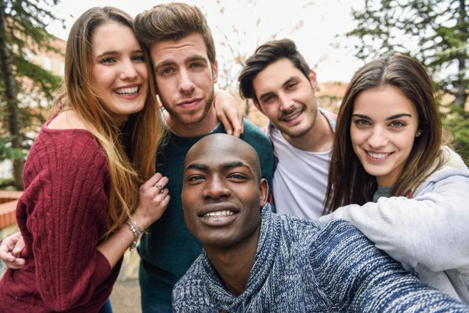 Happy group of men and women looking at camera and posing for picture