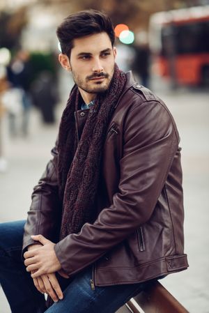 Man in leather coat waiting outside