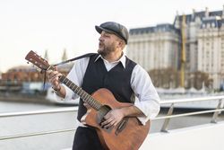 A street musician performing classic songs while playing guitar.