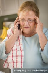 Shocked Older Adult Woman on Cell Phone in Kitchen 5qkxeE