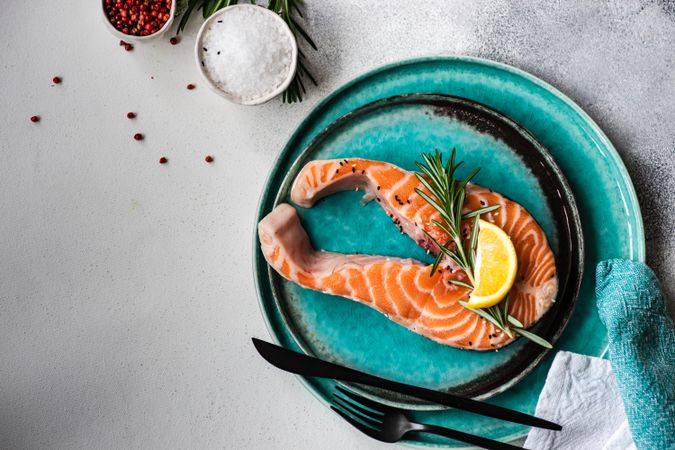 Top view of salmon fish and seasonings on stone background with copy space