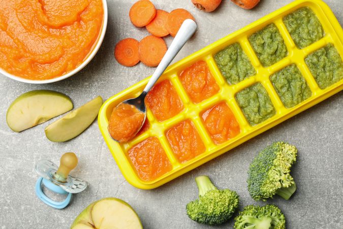 Composition with baby food on gray background, top view