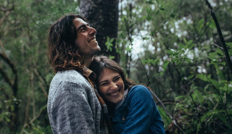 Beautiful woman embracing her boyfriend and smiling in rainforest