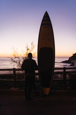 Man practicing paddle surfing with neoprene in a sunrise
