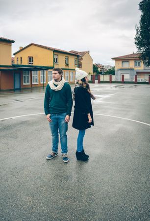 Couple standing away from each other in circle in sports court
