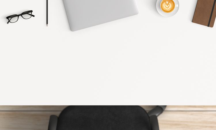 Modern workplace with laptop, coffee cup and notebook copy space on table background. Top view. Flat lay style.