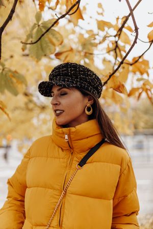 Smiling woman standing on autumn tree