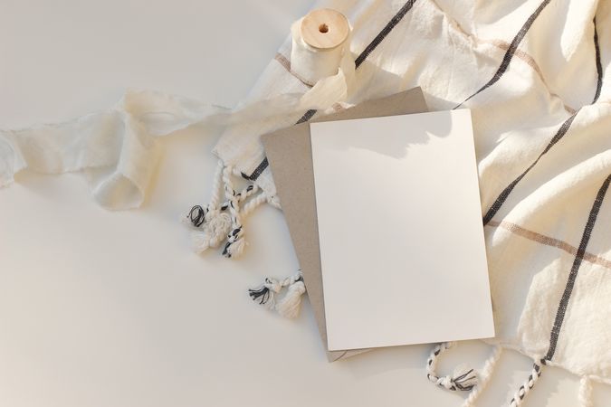 Blank greeting card with craft paper envelope in sunlight