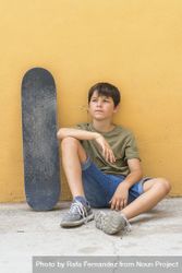 A serious boy with sitting skateboard alone 48BlnY