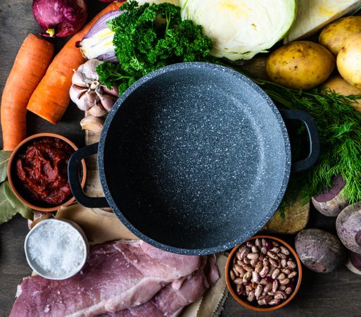 Ingredients for hearty soup surrounding pan